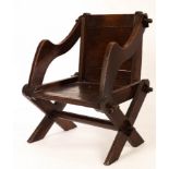 A child's Glastonbury chair with shaped outline and pegged frame,