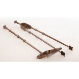 Two Arts & Crafts style steel fire irons including matching tongs and shovel with engraved patterns