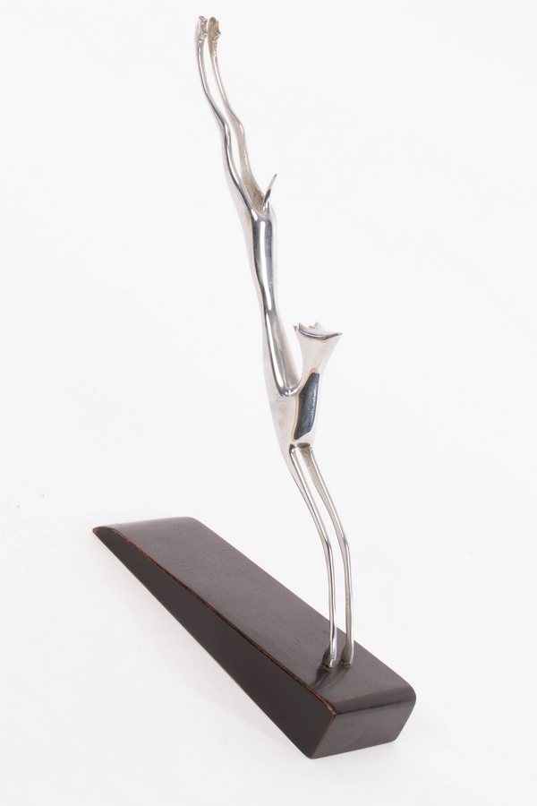 Hagenauer, a silvered metal stylised figure of a leaping gazelle, on dark wood base, stamped marks,