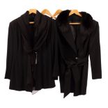 A black wool crepe trouser suit with chiffon tie collar and rouleau tie front and another black