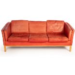 A Danish Stouby red leather three-seater sofa, with label,