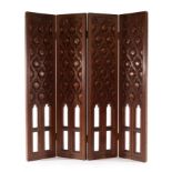 An Arts & Crafts four-fold table screen carved pomegranates in trellis designs with four Gothic