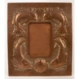 An Arts & Crafts copper frame of easel form, embossed fish and shells,