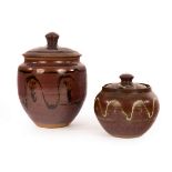 Winchcombe Pottery; two lidded jars with trailed decoration, 19cm and 12cm high/Note: unsigned,