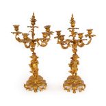 A pair of gilt metal candelabra with four-branches, five-lights and cherub bases,