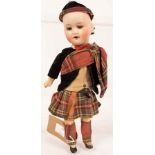 A bisque head doll in Highland dress,