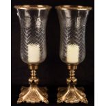 A pair of cut glass and gilt metal candle holders,