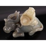 A Chinese grey jade, carved as a boy on the back of a buffalo,