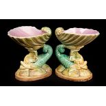 A pair of Majolica nautilus shells with dolphin supports,
