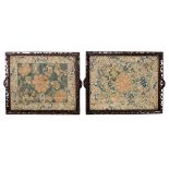A pair of late 19th Century needlework floral panels on silk within stylized borders,