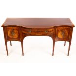 A mahogany serpentine front sideboard, crossbanded and fitted two cupboards and a central drawer,