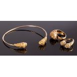 A 14k gold torc bangle with lion mask terminals, approximately 6.