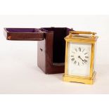 A gilt brass eight-day carriage clock, the porcelain dial with Roman numerals,