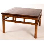 A Chinese Huanghuali square table with panelled top and rectangles to the frieze, on turned legs,