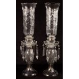 A pair of cut glass candle holders, hung with prismatic drops,