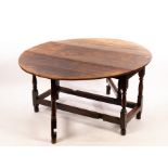 An oval oak gateleg table, the two-flap top on baluster turned legs and square stretchers,