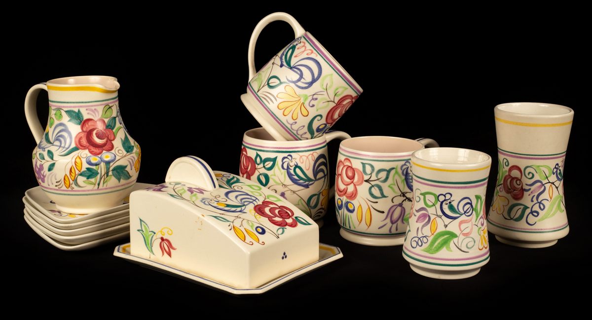Poole Pottery, a floral cheese dish and cover, 19cm long, three floral tankards, 11cm high,