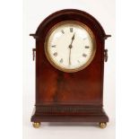 An Edwardian mahogany arch-top mantel clock on four ball feet,