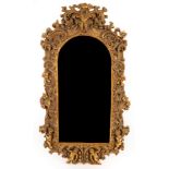 A gilt framed mirror, decorated foliate scrolls and putto,