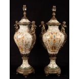 A pair of vase-shaped pottery lamps with gilt metal mounts, the handles modelled as cherubs,