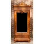 A late 19th Century walnut armoire with carved pediment, enclosed by a mirror door, on bun feet,
