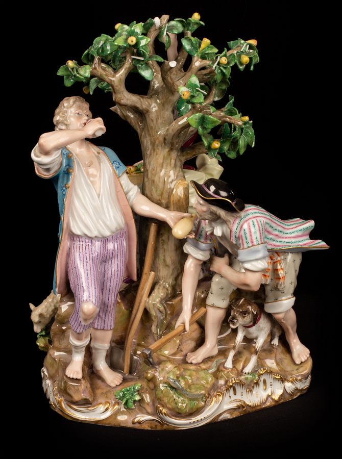 A large Meissen figure group of three farmers about a pear tree, with hound and sheep,