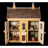 A large early 20th Century doll's house of eight rooms, to include a drawing room, a dining room,