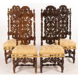 Four 17th Century style oak hall chairs with profusely carved backs,