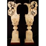 A pair of Italian alabaster ewer-shaped lamps, encrusted with flowers on pedestal bases, 67.
