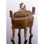 A Japanese bronze incense burner with two handles and four slender feet,