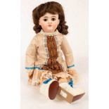 A bisque head doll with white boots and later clothes,