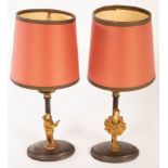 A pair of oxidized candlestick table lights, each with a gilt figure at the base,