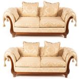 A pair of Victoria furniture two-seat sofas with carved scroll ends on turned feet,