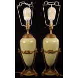 A pair of French table lamps of speckled green ceramic ovoid form on gilt metal tripod supports