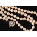 A single row pearl necklace, the graduated row of pearls to a diamond flowerhead cluster clasp, 44.