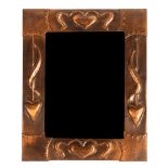 An Arts & Crafts style copper mirror, the frame embossed heart motifs,