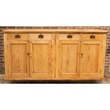 A pine cupboard enclosed by a pair of panel doors, with four drawers over,