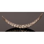 A Victorian crescent brooch, of seventeen graduated stones in silver fronted gold mount, 5cm long,