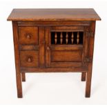An oak cupboard enclosed by a spindle turned door, fitted two drawers,