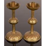 A pair of copper and brass candlesticks with lobed and scale decoration, the bases weighted, 26.