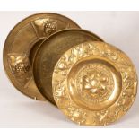 An Arts & Crafts style brass charger decorated repoussé foliage and central flower with Dutch