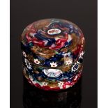 A circular snuff box, the metal overlaid with glass millefiori canes with faceted sides,