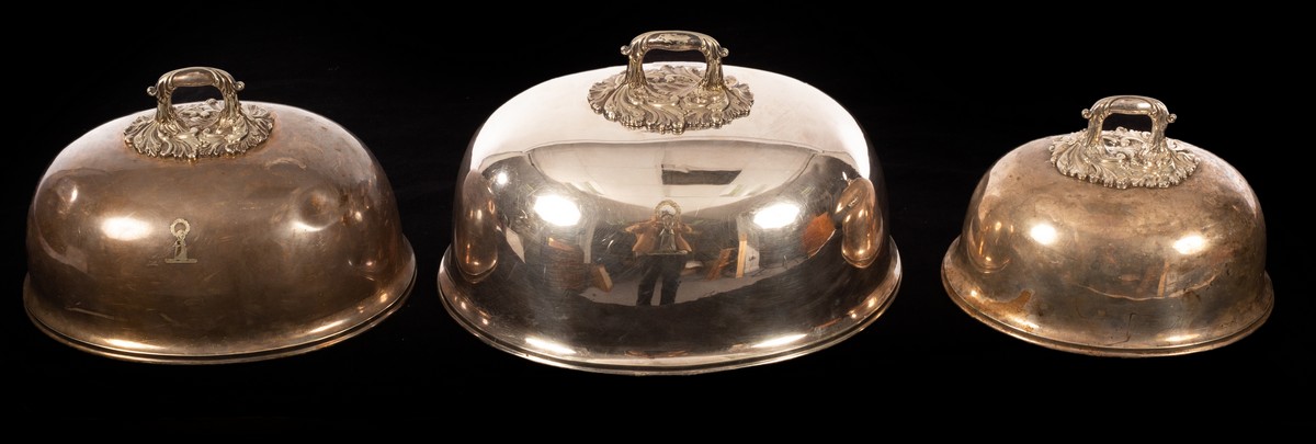 A set of three silver plated food domes, each with leaf scroll handle, crested, the largest 35.