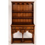A small oak dresser with shelves over, fitted five drawers on turned legs with a platform beneath,