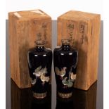 A pair of Japanese cloisonne vases, Meiji period, each depicting pigeons to a midnight blue ground,