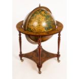 A modern terrestrial and celestial globe and stand forming a drinks cabinet,