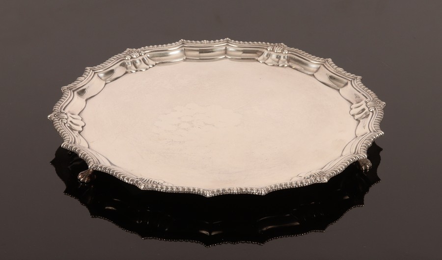 A silver salver, Birmingham 1936, with pie crust border and paw feet, 26.