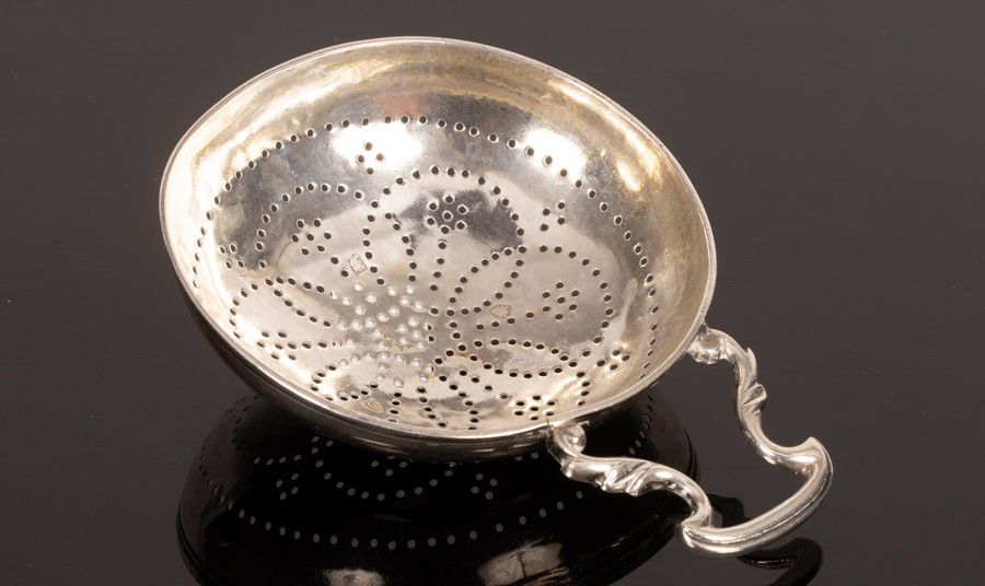 A George III silver strainer with shaped handle CONDITION REPORT: Slight split to