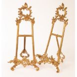 A pair of Rococo style gold painted, metal A-frames with easel backs,