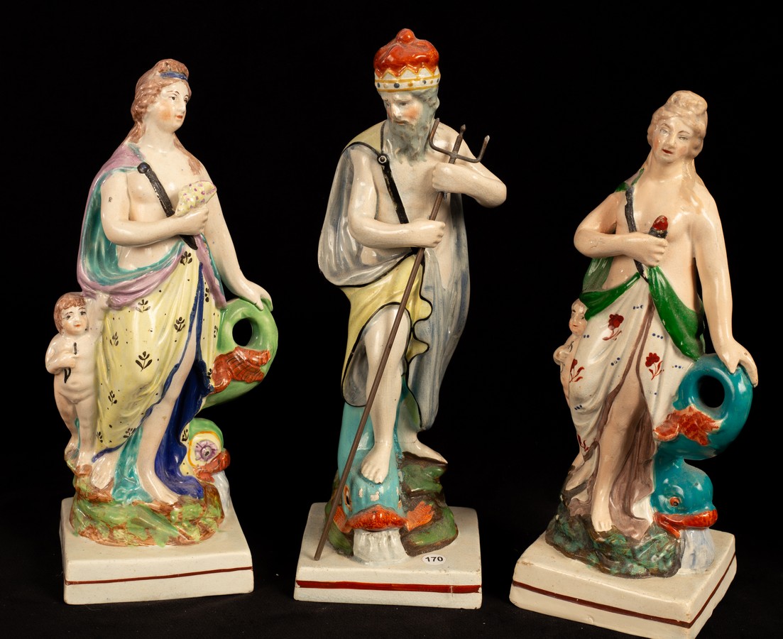 Three Staffordshire pearlware figures, two of Venus with Cupid beside a dolphin and one of Neptune,